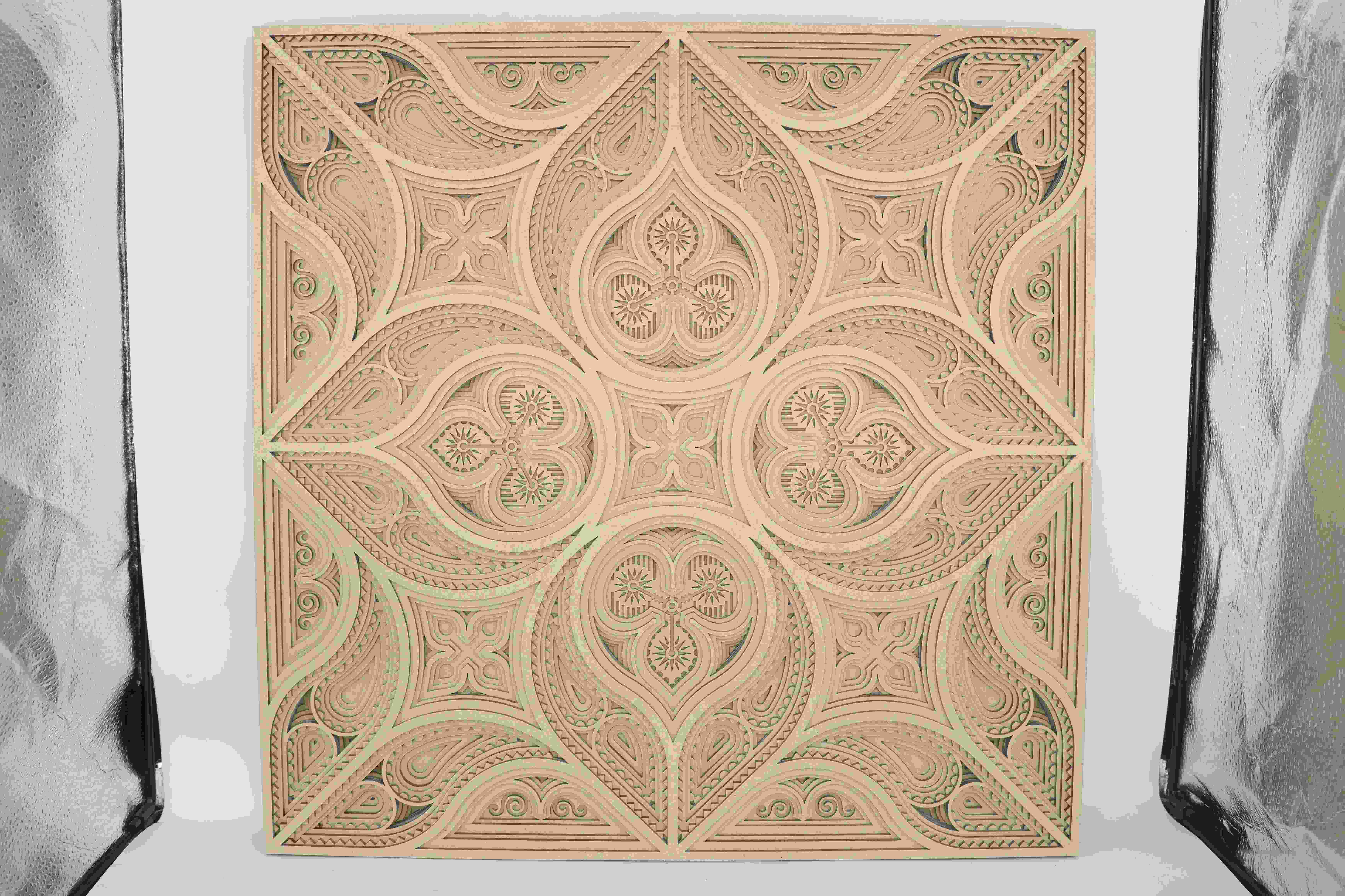 Una pieza de arte de pared en capas hecha de madera, cortada con precisión con un láser para formar patrones intrincados y bordes limpios